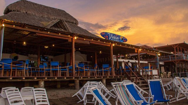 Sunset view of the exterior of Restaurante Vivian from the beach