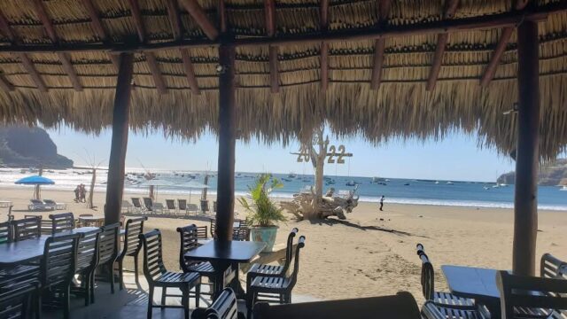 View out to the ocean under the palapa or rancho of Restaurante El Timón