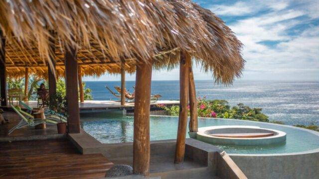 Clifftop infinity pool and restaurant at Hush Maderas overlooking Playa Maderas, San Juan del Sur