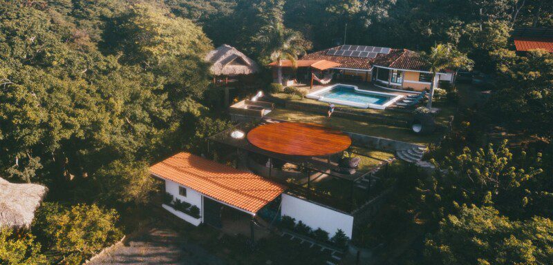 Sunset view from Todo Bien Nicaragua overlooking the Pacific Ocean and lush jungle landscape.