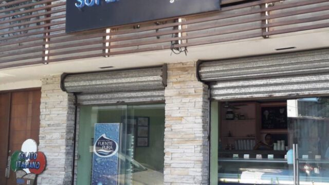 A colorful display of various gelato flavors at Gelateria SUPERFRUTTO in San Juan del Sur, with customers enjoying their treats outside