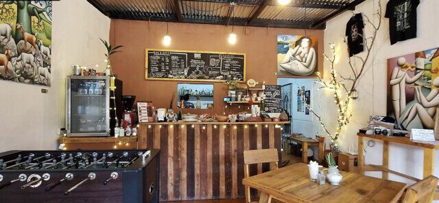 Interior of Origen Gallery & Coffee Shop in San Juan del Sur, featuring Nicaraguan artwork, handmade products, and cozy café seating.