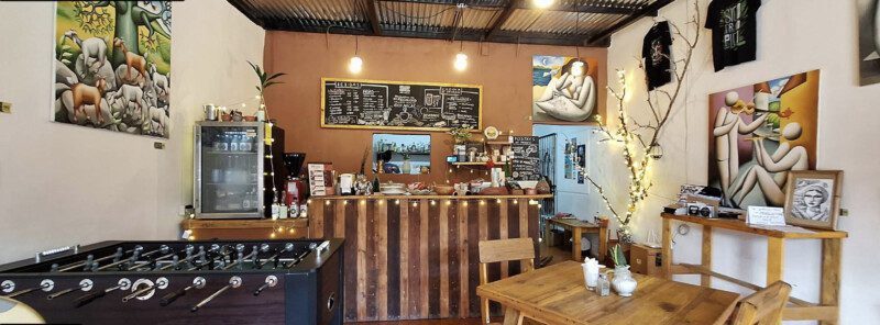 Interior of Origen Gallery & Coffee Shop in San Juan del Sur, featuring Nicaraguan artwork, handmade products, and cozy café seating.