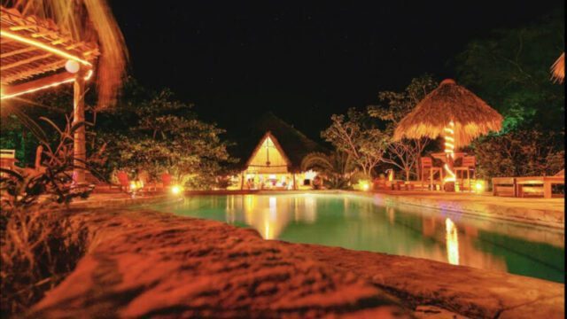 Outdoor dining area of Mango Rosa Restaurant & Bar in San Juan del Sur, featuring pool, tropical ambiance and open-air seating.