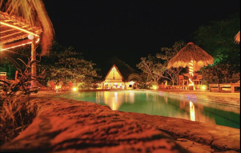 Outdoor dining area of Mango Rosa Restaurant & Bar in San Juan del Sur, featuring pool, tropical ambiance and open-air seating.