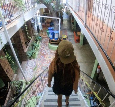 Interior of Café Oro in San Juan del Sur featuring eco-friendly design with reclaimed materials and recycled glass bottle walls.