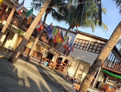 View of Hotel Anamar's beachfront pool area with guests enjoying the sun and ocean breeze in San Juan del Sur, Nicaragua