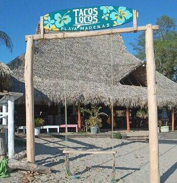 Beachside view of Tacos Locos with patrons enjoying authentic Mexican street food in San Juan del Sur, Nicaragua