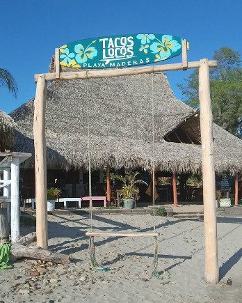 Beachside view of Tacos Locos with patrons enjoying authentic Mexican street food in San Juan del Sur, Nicaragua
