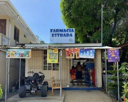 Farmacia Estrada storefront in San Juan del Sur, Nicaragua, offering a wide range of pharmaceutical services