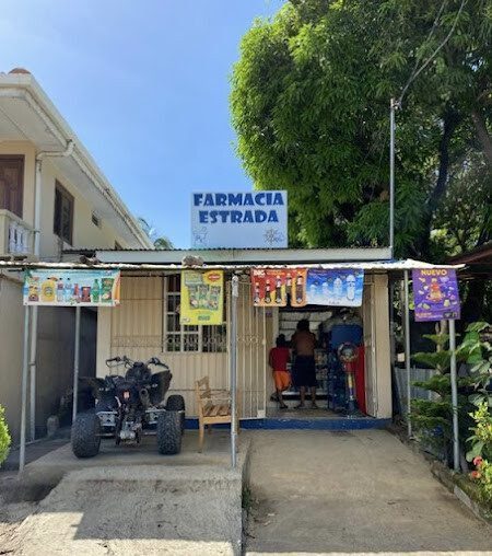 Farmacia Estrada storefront in San Juan del Sur, Nicaragua, offering a wide range of pharmaceutical services