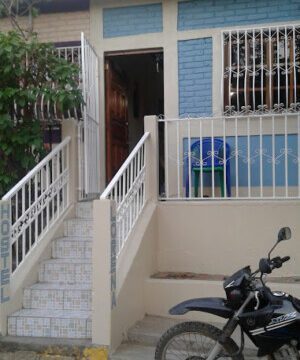 Exterior view of Lorena Surf Hostel showcasing its vibrant facade in San Juan del Sur, Nicaragua