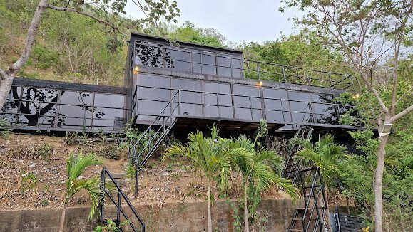 Exterior view of AquaViva Hotel Collection's container-style suites with panoramic glass walls overlooking the ocean in San Juan del Sur, Nicaragua
