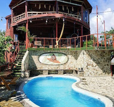 View of Magnific Rock Surf Resort & Yoga Retreat with pool and frontage of the building.