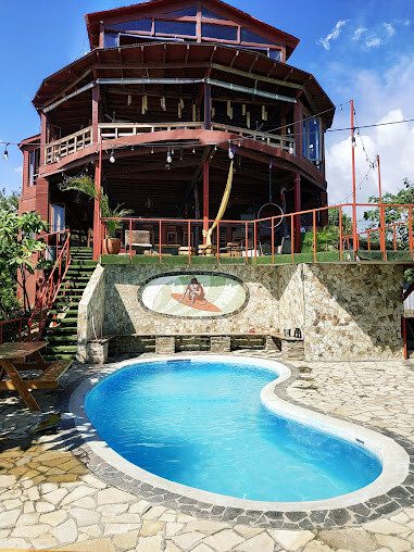 View of Magnific Rock Surf Resort & Yoga Retreat with pool and frontage of the building.