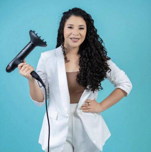 Image of Maria Jose Sanchez holding a hair dryer - Colochos Sanos curly hair salon by Maria Jose offering certified haircuts and products in San Juan del Sur Nicaragua