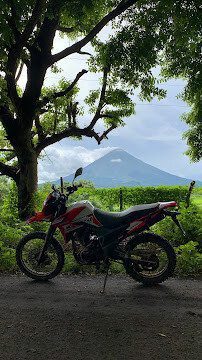 Premium rental motorcycle parked in San Juan del Sur with surf rack
