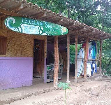 Surf instructor teaching beginner surfers on the beach at Playa Maderas