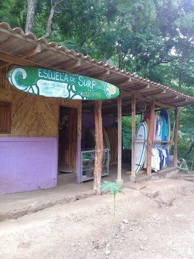 Surf instructor teaching beginner surfers on the beach at Playa Maderas