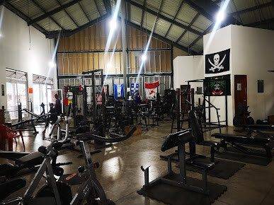Exterior view of Gymsito with gym signage and interior shot showing weightlifting equipment and cardio machines in San Juan del Sur
