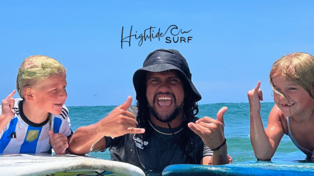 Hightide Surf School image of surf instructor with kids he's teaching on the waves
