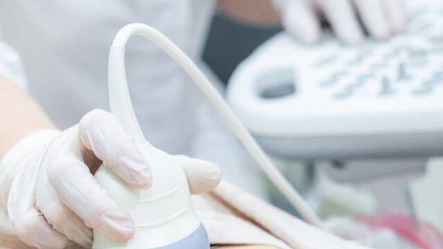 Dr Douglas Ultrasound image of an ultrasound operator doing an ultrasound on a patient's stomach