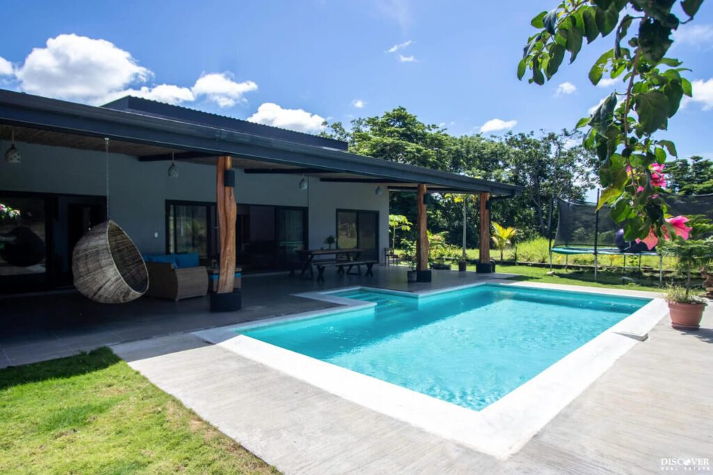 View of main house of equestrian estate listed by Discover Real Estate across pool