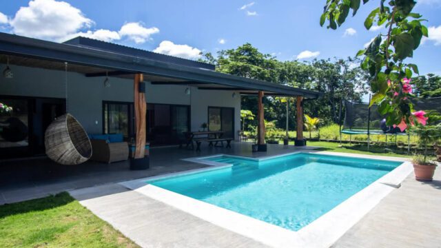 View of main house of equestrian estate listed by Discover Real Estate across pool
