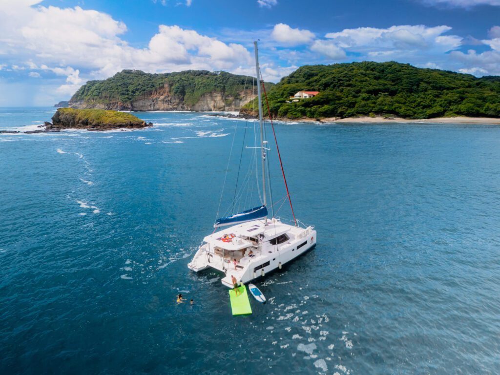 Close Up Shot of Santana Sail Yacht with People swimming in the water behind