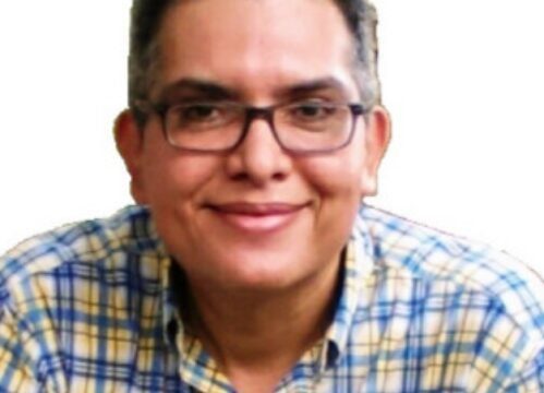 Computer and mobile phone repair technician Carlos Mora fixing laptop and phone